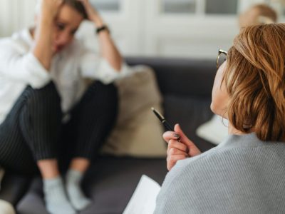 A therapist comforts a worried client during a counseling session.